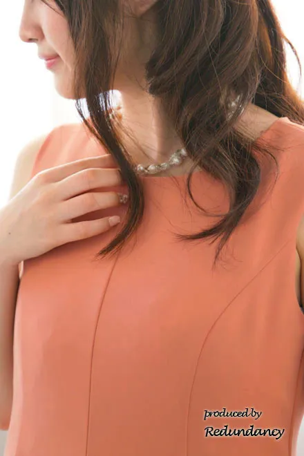 オレンジのネックレス付きフィットアンドフレアドレス