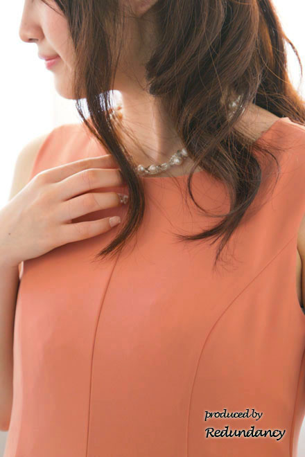 オレンジのネックレス付きフィットアンドフレアドレス