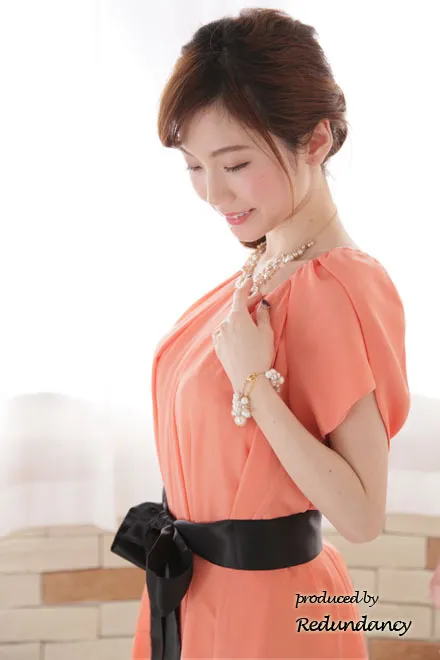 オレンジのウエストリボン付きシマープリーツドレス