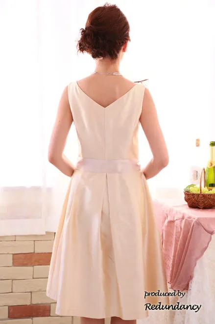 ライトベージュのウエストリボンミモレ丈シャンタンドレス