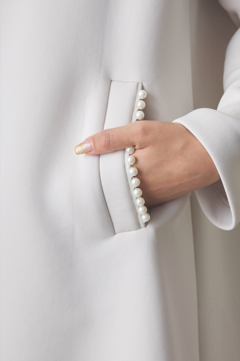 オフホワイトのパールボンディングコート