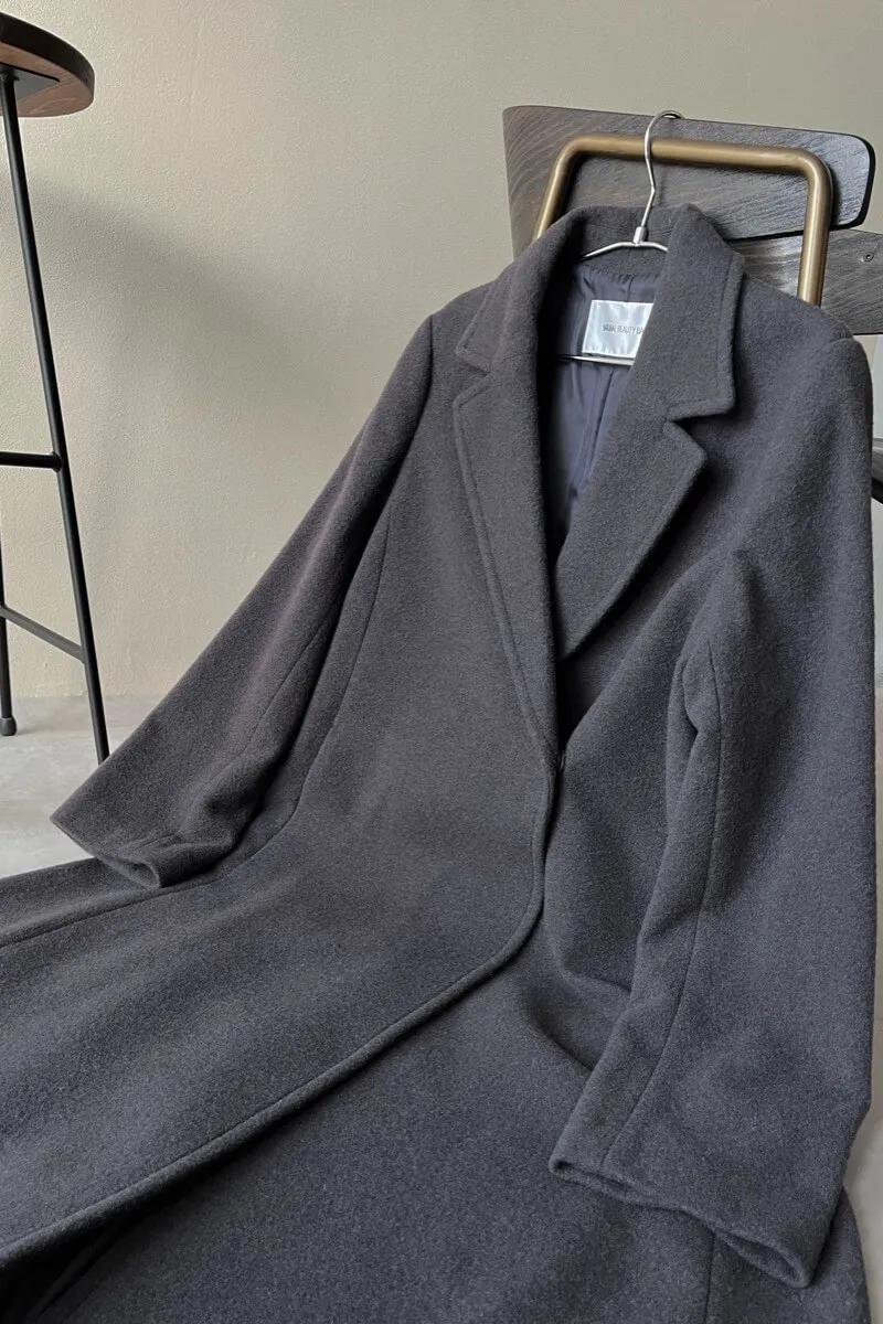 チャコールグレーのテーラーベルテッドロングコート