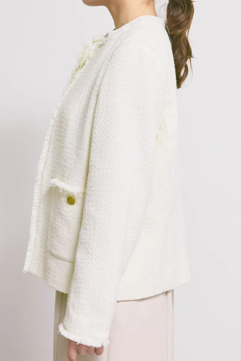 オフホワイトのツイードライクノーカラージャケット