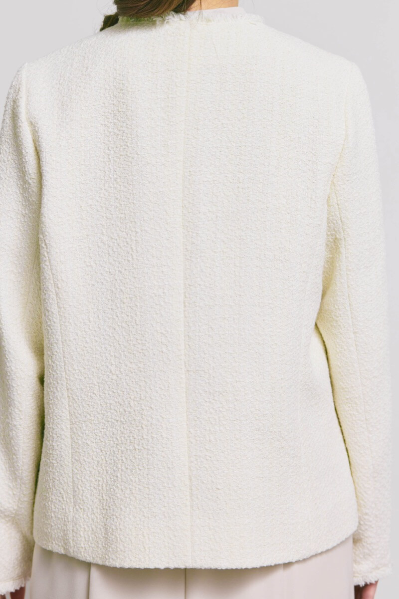 オフホワイトのツイードライクノーカラージャケット