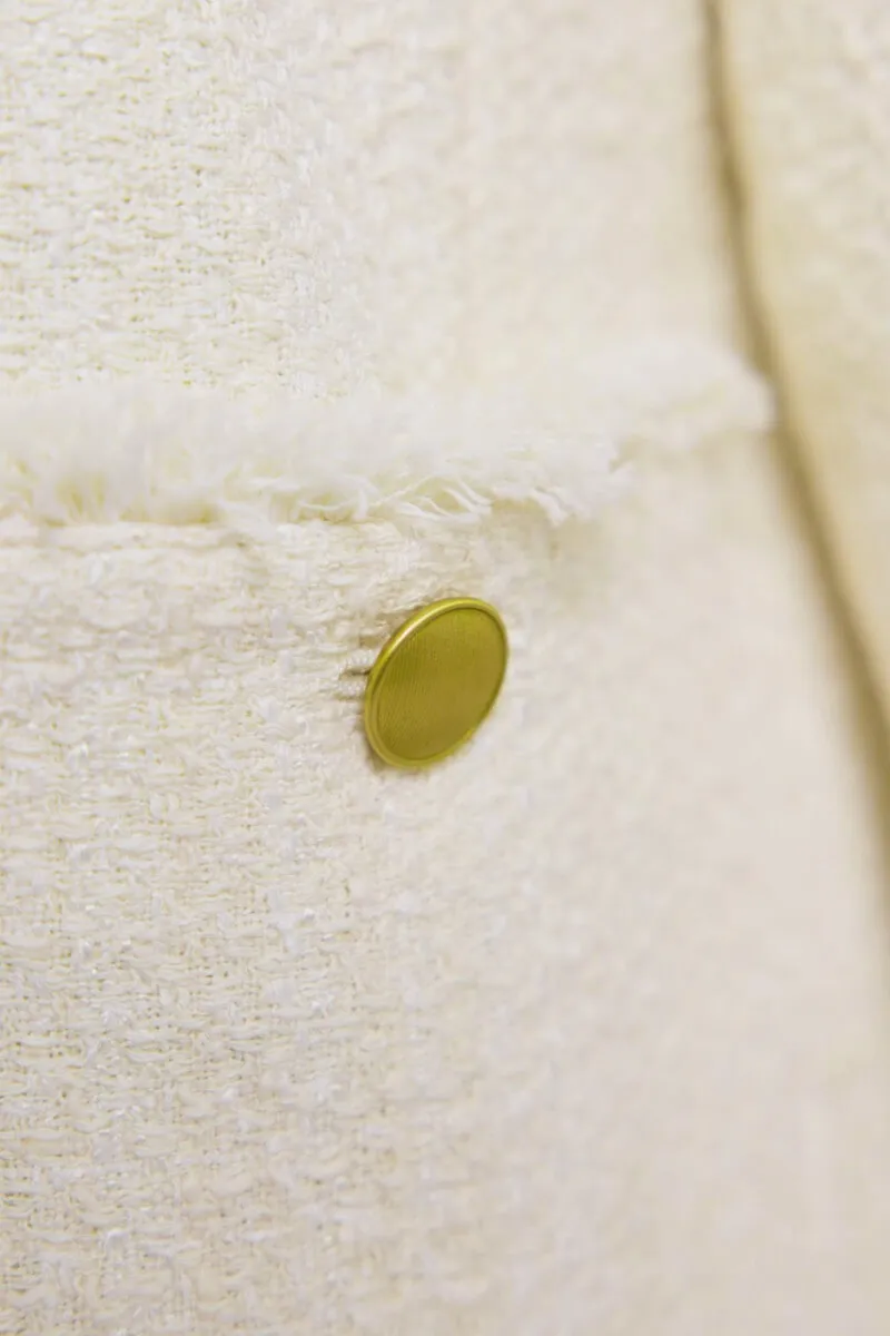 オフホワイトのツイードライクノーカラージャケット