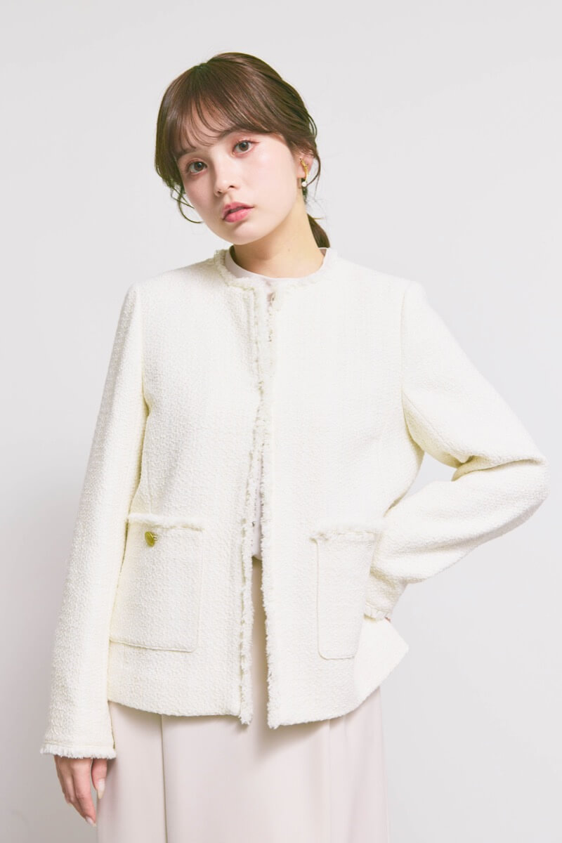 オフホワイトのツイードライクノーカラージャケット