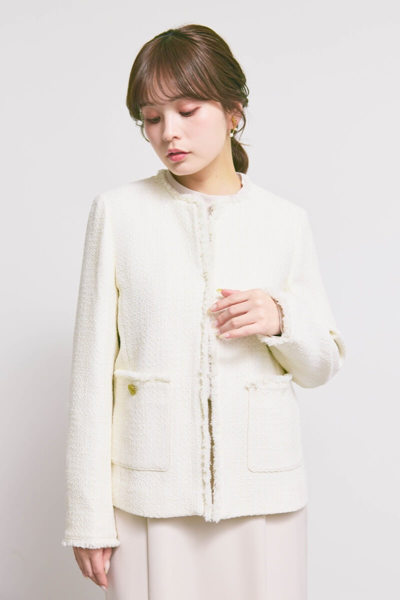 オフホワイトのツイードライクノーカラージャケット